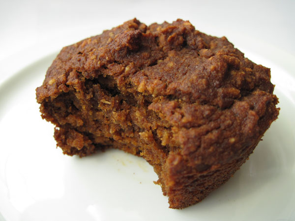 (muffin on a plate with a bite taken out of it)